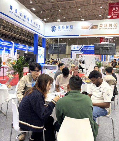 Visitors discussing bakery equipment at the exhibition